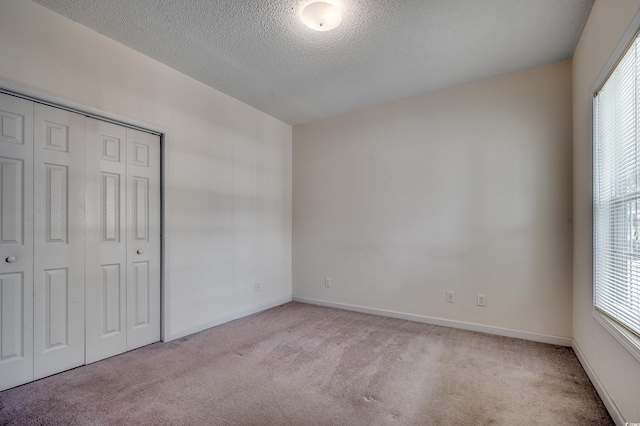1058 Sea Mountain Hwy Unit 4-203, North Myrtle Beach, SC 29582 - unfurnished bedroom with carpet flooring, a textured ceiling, multiple windows, and a closet