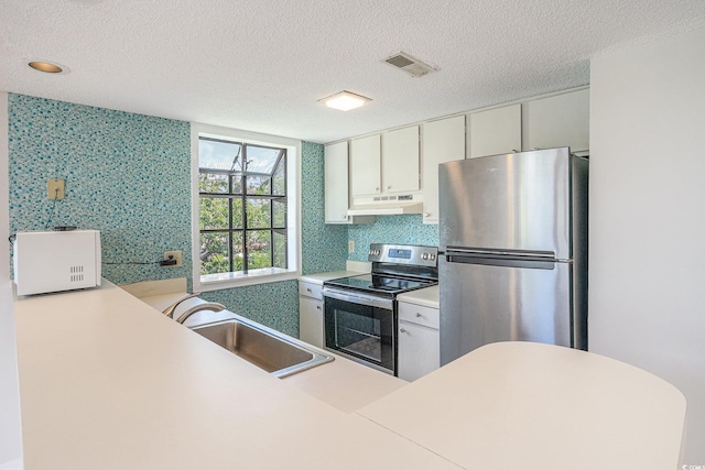 351 Lake Arrowhead Rd Unit 24-396, Myrtle Beach, SC 29572 - kitchen featuring stainless steel appliances, under cabinet range hood, a textured ceiling, light countertops, and wallpapered walls