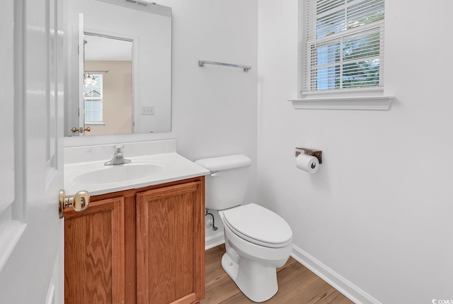 bathroom featuring toilet, wood finished floors, baseboards, and vanity