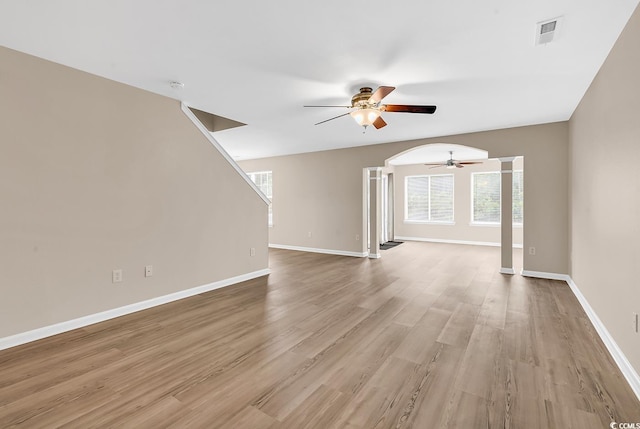 unfurnished living room featuring ceiling fan, baseboards, and light wood finished floors