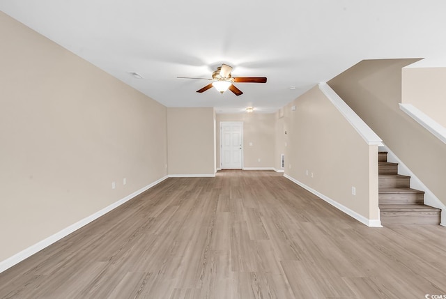 unfurnished living room with a ceiling fan, light wood-style flooring, stairway, and baseboards