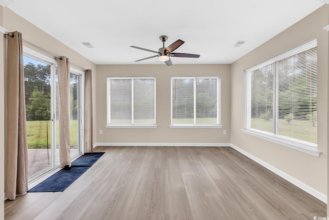 unfurnished sunroom featuring wood finished floors and baseboards