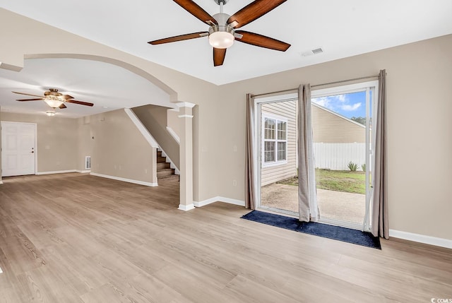 spare room with ceiling fan, arched walkways, stairs, and baseboards