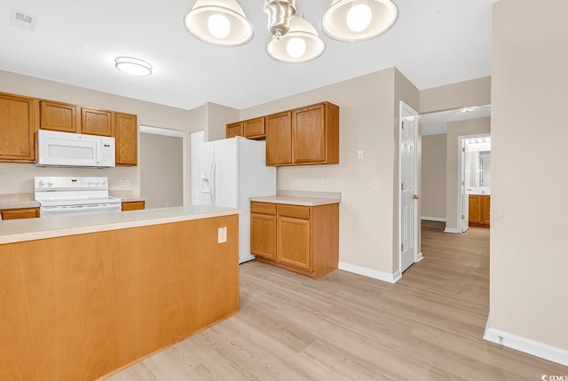 kitchen featuring white appliances, light countertops, baseboards, and light wood finished floors
