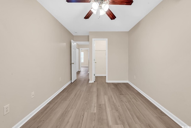 unfurnished room with ceiling fan, light wood-style floors, and baseboards