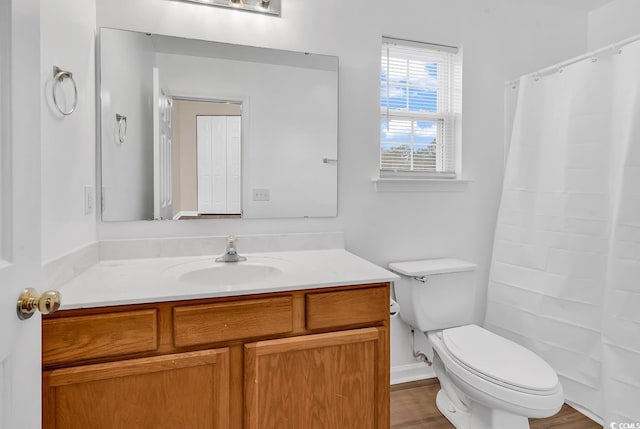 bathroom with vanity, toilet, a shower with shower curtain, and wood finished floors