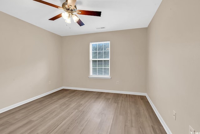 spare room with a ceiling fan, wood finished floors, and baseboards