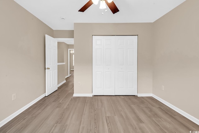 unfurnished bedroom with light wood-style floors, baseboards, a closet, and ceiling fan