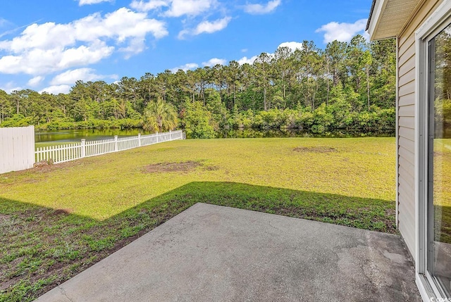 view of yard with a patio area, a water view, and a wooded view