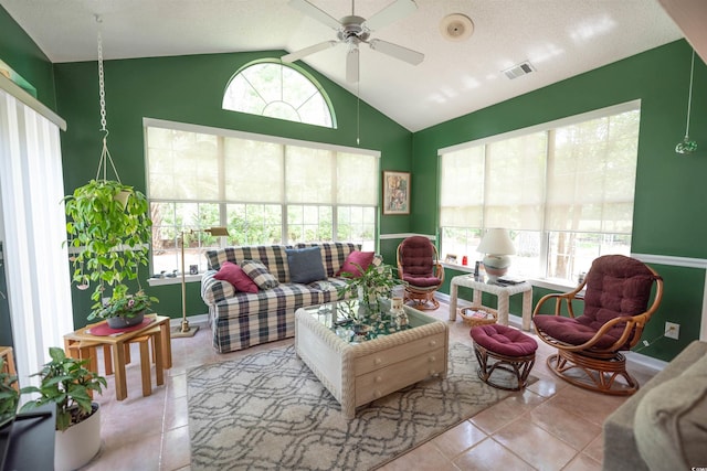 tiled living room featuring vaulted ceiling, a ceiling fan, and baseboards
