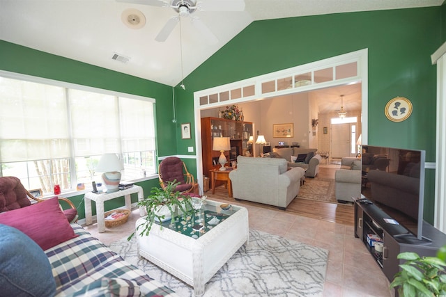 living room with tile patterned floors, a ceiling fan, and high vaulted ceiling