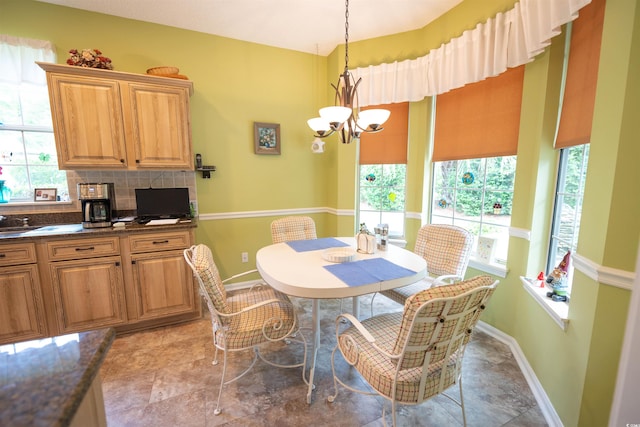 dining room with healthy amount of natural light, a chandelier, and baseboards