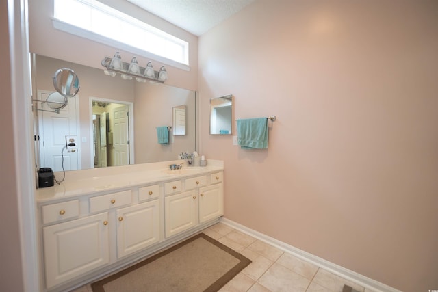 bathroom with baseboards, tile patterned floors, and vanity