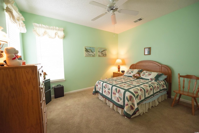 bedroom with carpet floors, a ceiling fan, baseboards, and a textured ceiling
