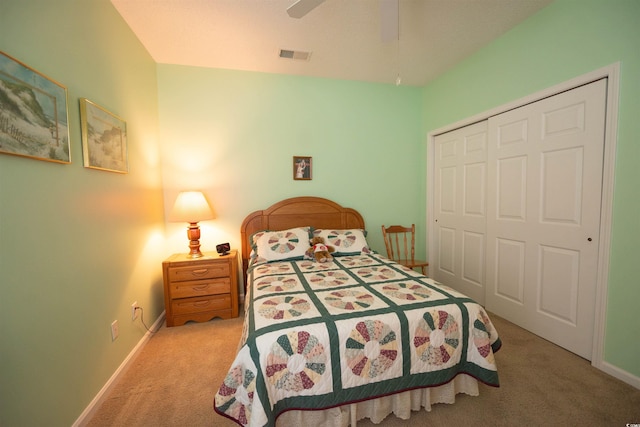 carpeted bedroom featuring a closet, baseboards, and a ceiling fan