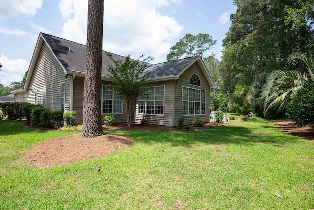 rear view of property with a yard and a shingled roof
