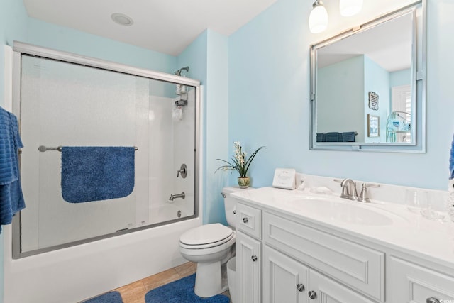 bathroom featuring toilet, vanity, and combined bath / shower with glass door