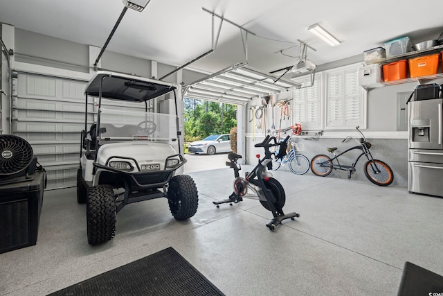 garage featuring stainless steel fridge with ice dispenser and a garage door opener