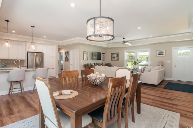 dining area with recessed lighting, wood finished floors, ornamental molding, a chandelier, and a ceiling fan