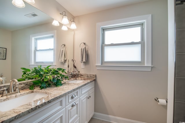 bathroom featuring double vanity and baseboards