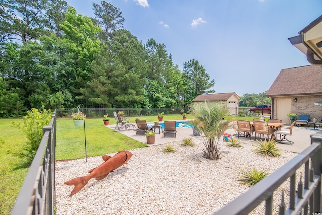 view of yard featuring a patio area, an outdoor structure, and outdoor dining space
