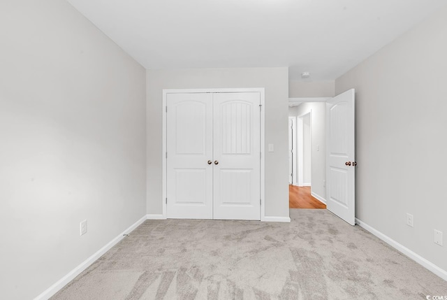 unfurnished bedroom featuring a closet, carpet floors, and baseboards