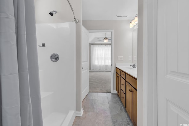 full bathroom with a shower, ceiling fan, vanity, and baseboards