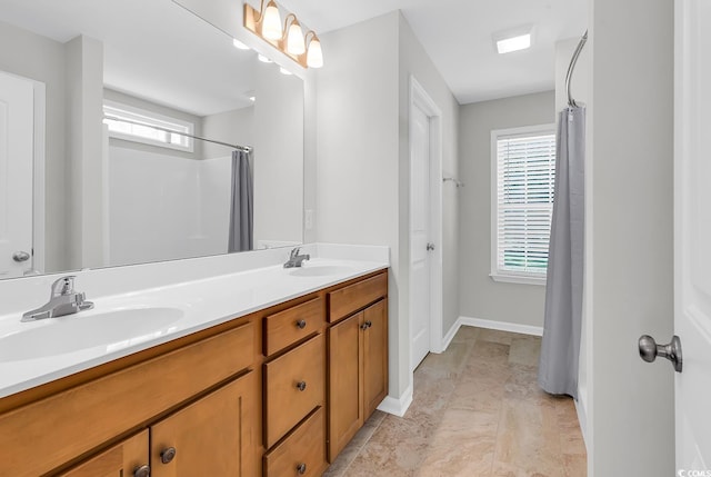 full bathroom featuring plenty of natural light, double vanity, baseboards, and curtained shower