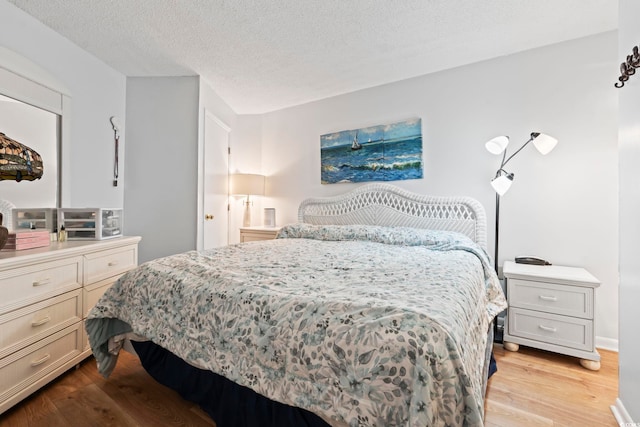 bedroom featuring light wood-style flooring and a textured ceiling