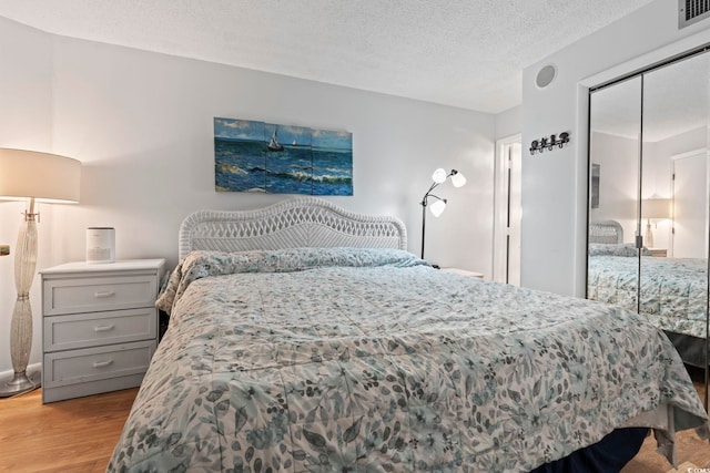bedroom with wood finished floors, a closet, and a textured ceiling
