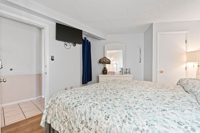 bedroom featuring wood finished floors and a textured ceiling
