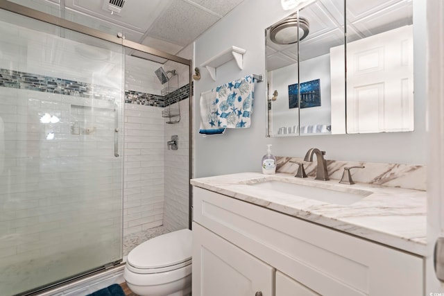 bathroom with toilet, a shower stall, and vanity