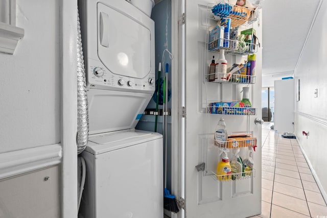 clothes washing area featuring estacked washer and dryer and light tile patterned floors