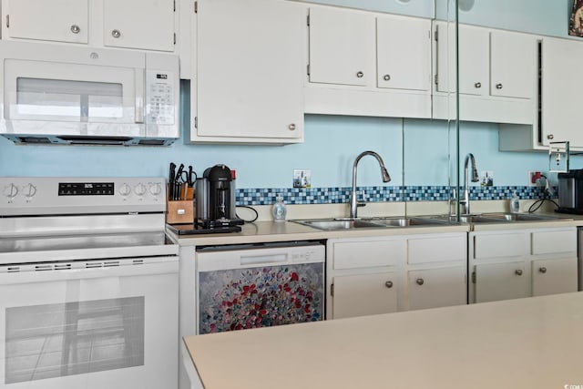 kitchen featuring white appliances, white cabinets, backsplash, light countertops, and a sink