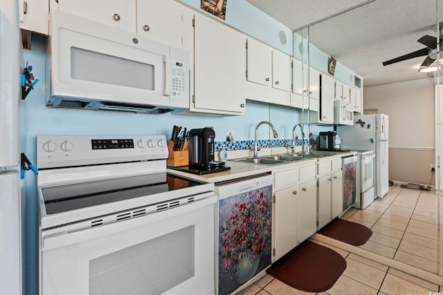kitchen featuring white appliances, a sink, ceiling fan, white cabinets, and a textured ceiling
