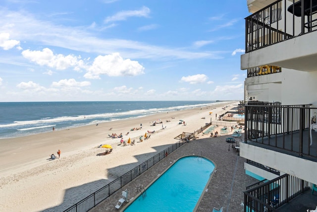 community pool featuring view of water and beach