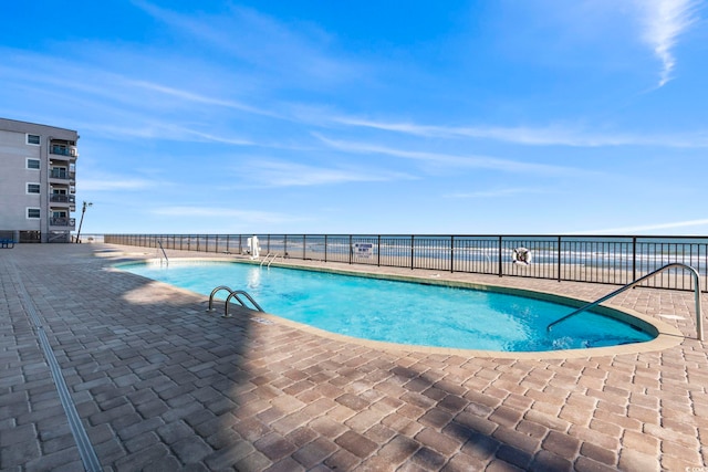 community pool featuring fence and a patio
