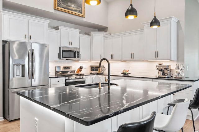 122 New Paradise Way, Myrtle Beach, SC 29588 - kitchen featuring stainless steel appliances, a sink, decorative backsplash, a breakfast bar, and a center island with sink