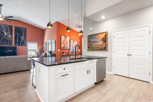 kitchen featuring a sink, dishwasher, open floor plan, dark countertops, and ceiling fan