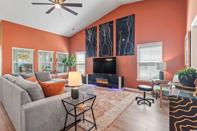 living room featuring ceiling fan, high vaulted ceiling, and wood finished floors