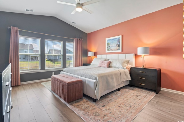 bedroom with vaulted ceiling, light wood-type flooring, baseboards, and ceiling fan