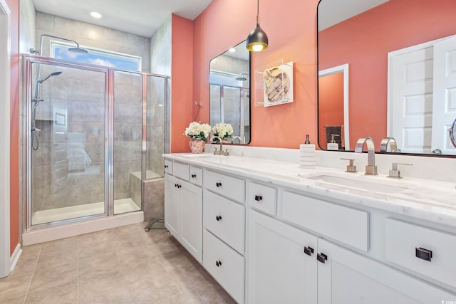 bathroom featuring a shower stall, tile patterned floors, and double vanity