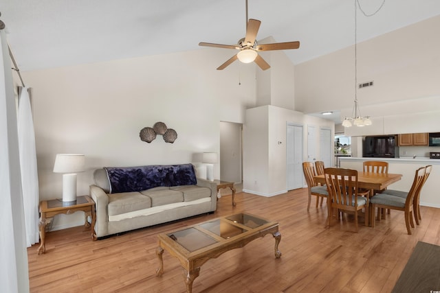 4940 Windsor Green Way Unit 301, Myrtle Beach, SC 29579 - living area featuring a ceiling fan, light wood-style flooring, high vaulted ceiling, and a chandelier
