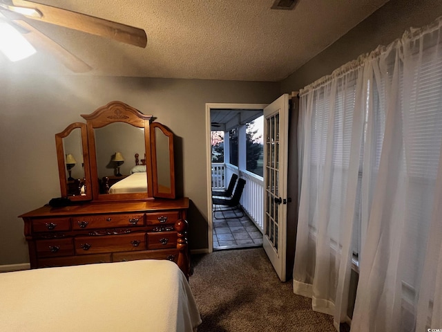 carpeted bedroom with access to exterior, ceiling fan, and a textured ceiling