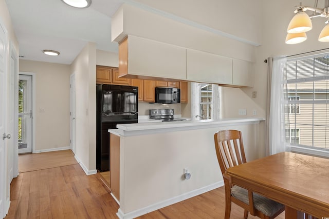 4940 Windsor Green Way Unit 301, Myrtle Beach, SC 29579 - kitchen featuring black appliances, light wood-type flooring, a peninsula, light countertops, and baseboards