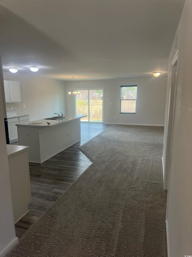 198 Foxford Dr, Conway, SC 29526 - unfurnished living room featuring a chandelier, baseboards, dark wood-type flooring, and a sink
