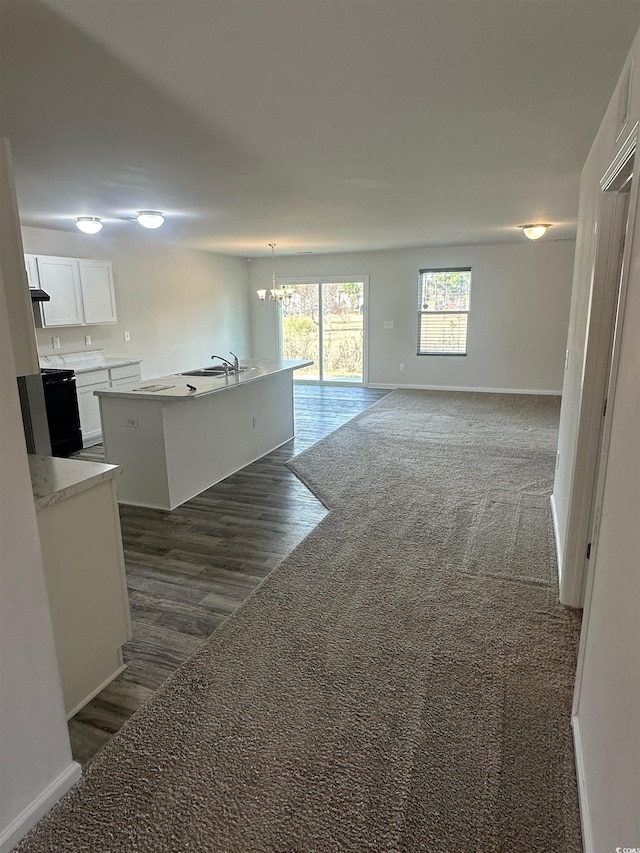 198 Foxford Dr, Conway, SC 29526 - unfurnished living room featuring a chandelier, baseboards, dark wood-style floors, a sink, and dark colored carpet