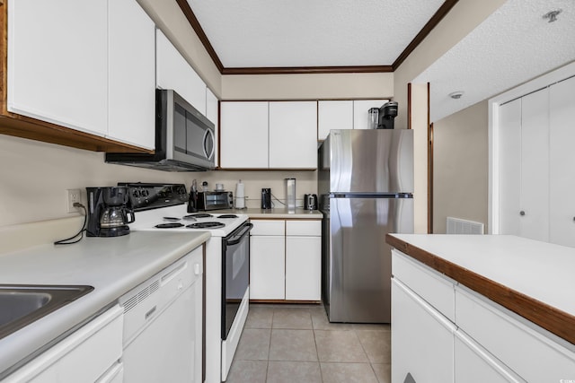4350 Intercoastal Dr Unit 2402, Little River, SC 29566 - kitchen with stainless steel appliances, white cabinetry, a textured ceiling, light countertops, and light tile patterned flooring