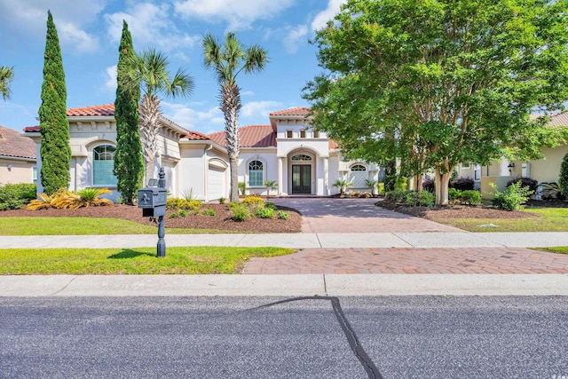 7202 Seville Dr, Myrtle Beach, SC 29572 - mediterranean / spanish-style home with decorative driveway, a tiled roof, stucco siding, and an attached garage