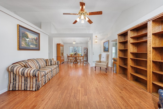 living area featuring light wood-style flooring, ceiling fan, and baseboards